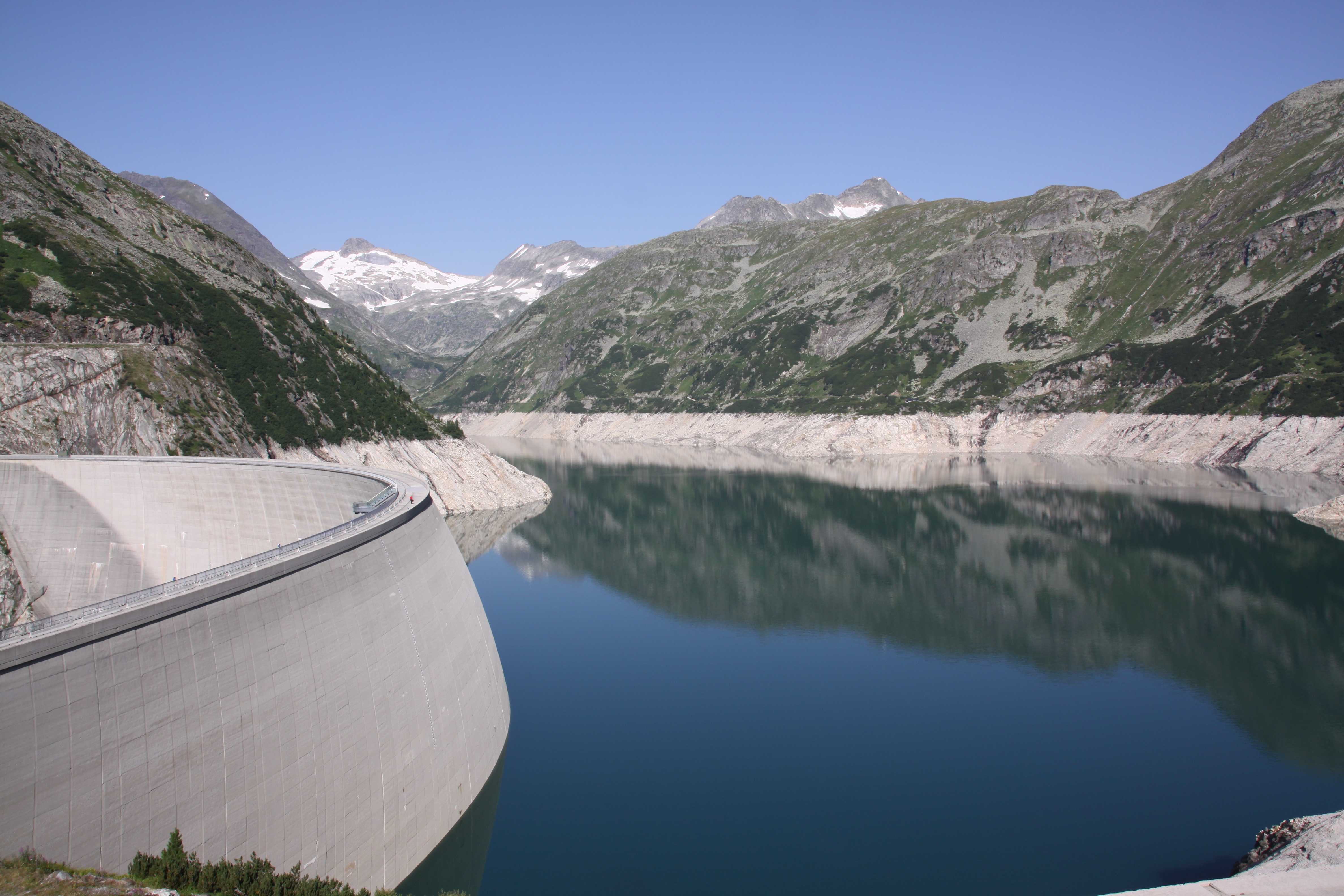 Staudamm und Stausee in bergiger Landschaft