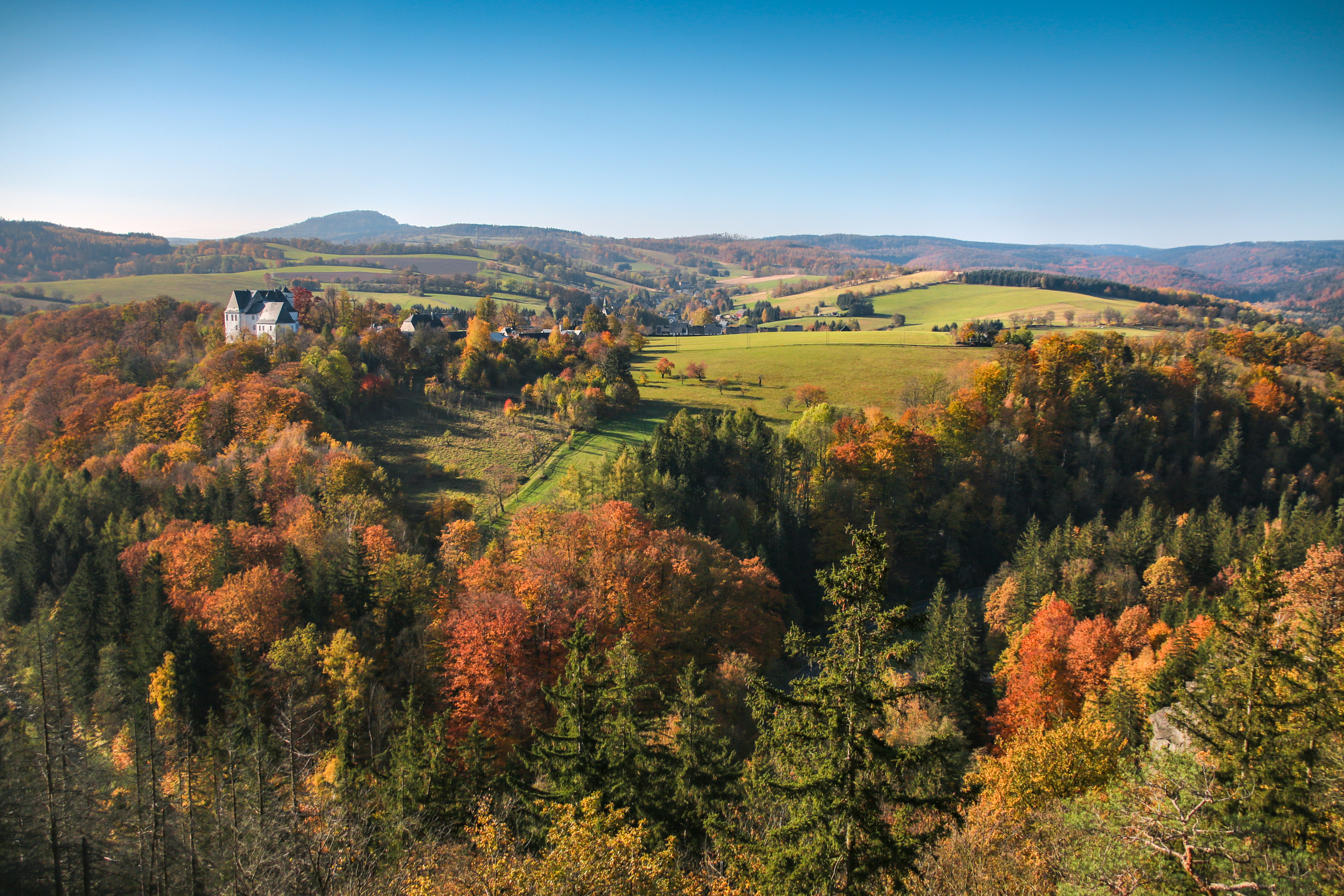 Herbstliche Landschaft im Erzgebirge mit Blick auf ein Schloss