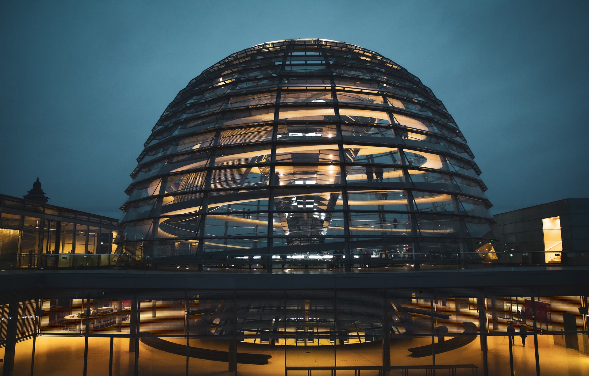 Das Bild zeigt die berühmte Glaskuppel des Reichstagsgebäudes in Berlin, dem Sitz des Deutschen Bundestages, bei Nacht.